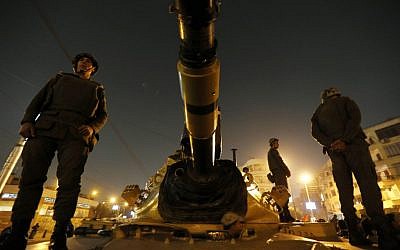 Egyptian soldiers stand guard on top a tank in front of the presidential palace in Cairo, Egypt, Sunday, Dec. 9  (photo credit: AP/Petr David Josek)