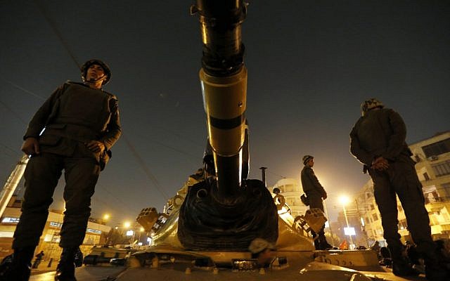 Egyptian soldiers stand guard on top a tank in front of the presidential palace in Cairo, Egypt, Sunday, Dec. 9 (photo credit: AP/Petr David Josek) Egyptian soldiers stand guard on top a tank in front of the presidential palace in Cairo, Egypt, Sunday, Dec. 9 (photo credit: AP/Petr David Josek)