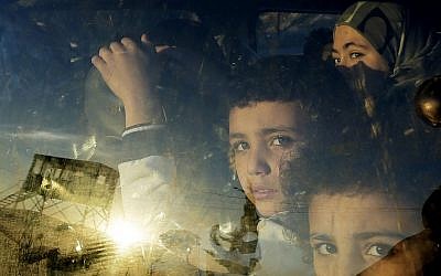 Syrian children look through their car window as they cross into Lebanon with their families at the border crossing, in Masnaa, eastern Lebanon, on Friday. (photo credit: AP Photo/Hassan Ammar)