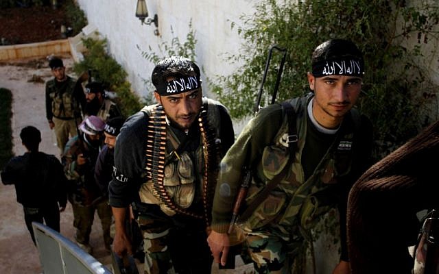 Syrian rebel fighters of “The Beloved of Allah” brigade carry their weapons before battling government forces on the outskirts of Aleppo in November (photo credit: AP/Khalil Hamra)