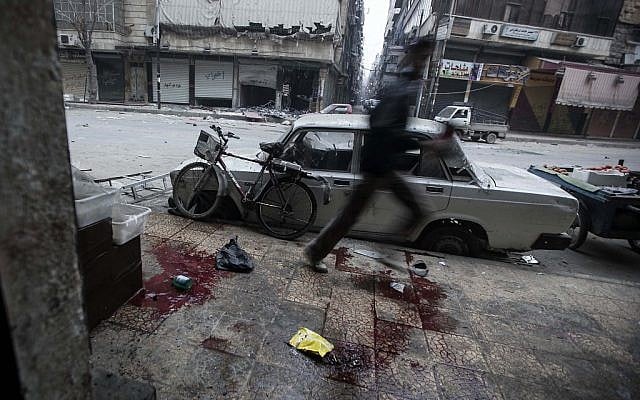 A Syrian man runs for cover during heavy fighting between Free Syrian Army fighters and government forces in Aleppo, Syria on Monday, Dec. 3 (photo credit: AP/Narciso Contreras)