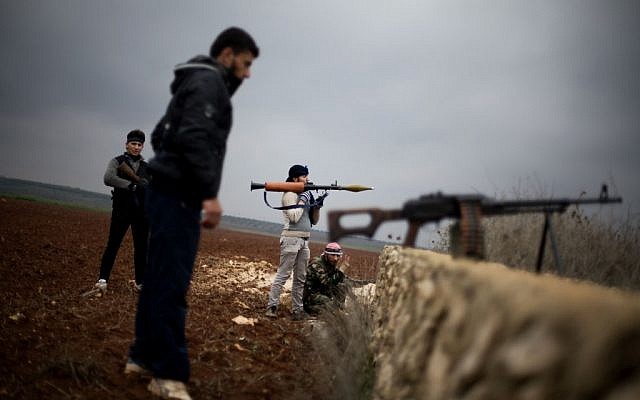 Free Syrian Army fighters take their positions, close to a military base, near Azaz, Syria, Monday, Dec. 10 (photo credit: AP/Manu Brabo)