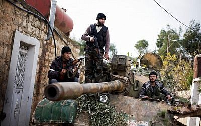 Kurdish members of the FSA are seen on a tank stolen from the Syrian Army in Fafeen village, north of Aleppo province, Syria, Wednesday, Dec 12, 2012. (photo credit: Manu Brabo/AP)