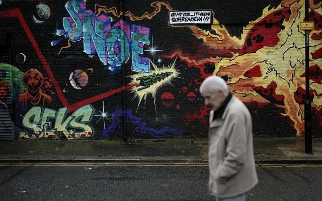 A man walks past street art in east London, Thursday, December 20, 2012. (photo credit: Matt Dunham/AP) A man walks past street art in east London, Thursday, December 20, 2012. (photo credit: Matt Dunham/AP)