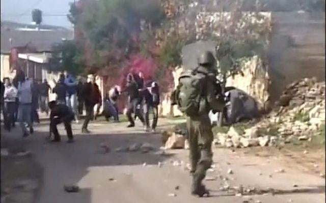 An IDF soldier confronts rioting Palestinians (photo credit: screen capture YouTube/MrDorkhan)