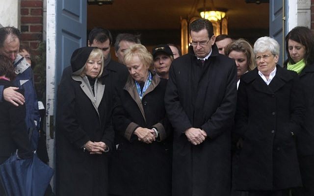 Connecticut Gov. Dan Malloy, center, stands with other officials to observe a moment of silence Friday while bells ring 26 times in Newtown, Conn., in honor of the victims killed last Friday during the shooting at Sandy Hook Elementary School. (photo credit: AP Photo/Seth Wenig)