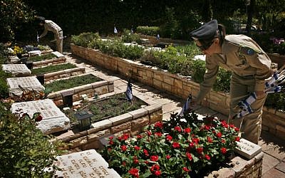 Soldiers place flags on graves at Mount Herzl Military cemetery in Jerusalem to mark Memorial Day in 2012. (photo credit: Michal Fattal/Flash90)