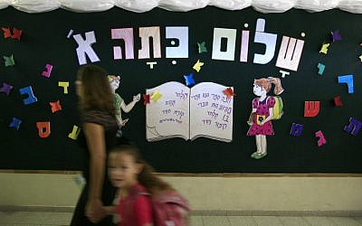 A mother and daughter walk by a sign greeting new first grade students in Jerusalem. (photo credit: Nati Shohat/Flash 90)
