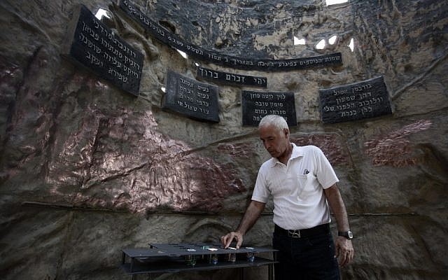A man lighting a candle inside the monument in 2009. (photo credit: Abir Sultan/Flash90)