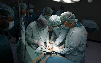 A team of surgeons work on a patient (Photo credit: Abed Rahim Khatib/Flash 90)