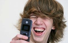 Israeli teen uses his cellphone (Photo credit: Moshe Shai/Flash90)