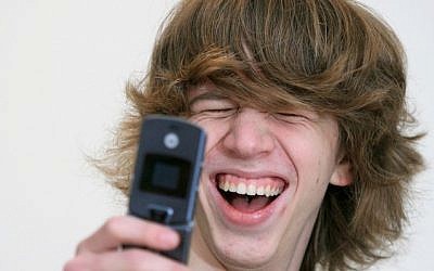 Israeli teen uses his cellphone (Photo credit: Moshe Shai/Flash90)