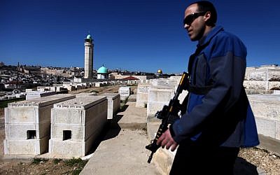 A security guard patrols the Mount of Olives in Jerusalem during a ministerial visit. (photo credit: Abir Sultan/Flash90)