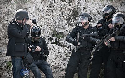 A photojournalist takes a photo of riot policemen during clashes in east Jerusalem in February of 2011. (Illustrative photo: Ruben Salvadori/Flash 90)