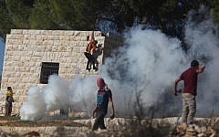 A Palestinian protester hurls stones at Israeli soldiers during a protest against settlement activity in the West Bank village of Nabi Saleh near Ramallah, Friday, November 30, 2012 (photo credit: Issam Rimawi/Flash90)