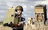 A child in Ashkelon holds a homemade Menorah in front of the Iron Dome unit stationed in the city.  The holiday of Hanukkah begins Saturday night (photo credit: Edi Israel/FLASH90)