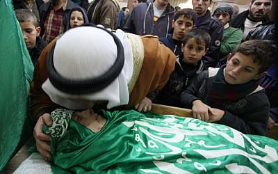 Palestinians bear the corpse of Mohammed Salayme during his funeral procession on December 13 in the West Bank city of Hebron. Israeli police said Salayme was shot after threatening border policeman in the city with a weapon, which turned out to be a toy. (photo credit: Issam Rimawi/Flash90)