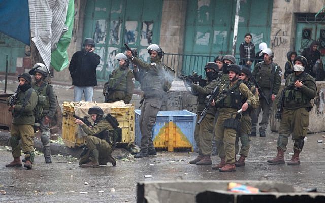 Israeli soldiers fire teargas canisters at Palestinian protesters in the West Bank city of Hebron on Thursday after the funeral of a teen who was shot dead by an Israeli soldier the night prior. (photo credit: Issam Rimawi/Flash90) Israeli soldiers fire teargas canisters at Palestinian protesters in the West Bank city of Hebron on Thursday after the funeral of a teen who was shot dead by an Israeli soldier the night prior. (photo credit: Issam Rimawi/Flash90)
