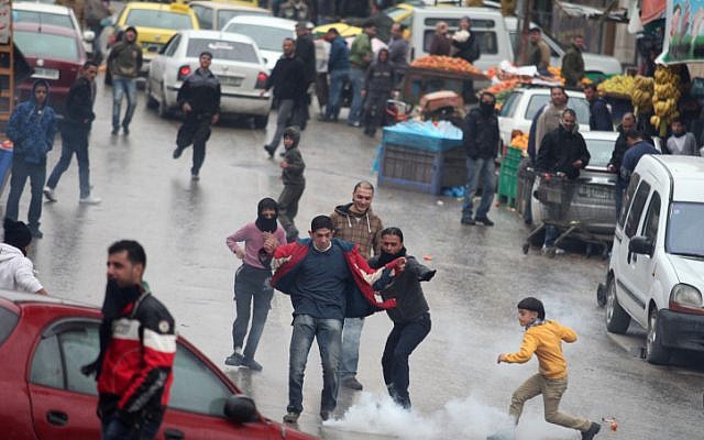 Palestinians clash with Israeli soldiers following the funeral of Mohammed Suleima, in the West Bank city of Hebron, Thursday, December 13 (photo credit: Issam Rimawi/Flash90) Palestinians clash with Israeli soldiers following the funeral of Mohammed Suleima, in the West Bank city of Hebron, Thursday, December 13 (photo credit: Issam Rimawi/Flash90)