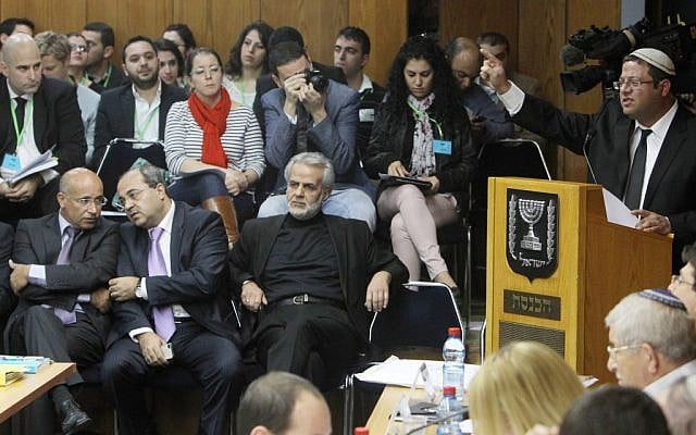 Would-be MK Itamar Ben Gvir, a far-right candidate whose own Otzma Leyisrael party has been accused of racism, speaks at Wednesday's Knesset Election Committee meeting where a vote was passed banning Arab parliament member Hanin Zoabi from running in the upcoming elections. Arab MKs including Ahmed Tibi (second from left) look on. (Photo credit: Miriam Alster/FLASH90) Would-be MK Itamar Ben Gvir, a far-right candidate whose own Otzma Leyisrael party has been accused of racism, speaks at Wednesday's Knesset Election Committee meeting where a vote was passed banning Arab parliament member Hanin Zoabi from running in the upcoming elections. Arab MKs including Ahmed Tibi (second from left) look on. (Photo credit: Miriam Alster/FLASH90)
