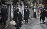 Ultra Orthodox men walk the streets of Jerusalem in the rain on Friday, December 21 (photo credit: Yonatan Sindel/Flash90)