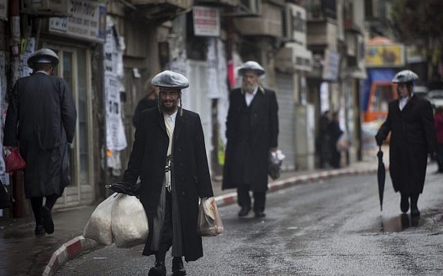 Ultra Orthodox men walk the streets of Jerusalem in the rain on Friday, December 21 (photo credit: Yonatan Sindel/Flash90)