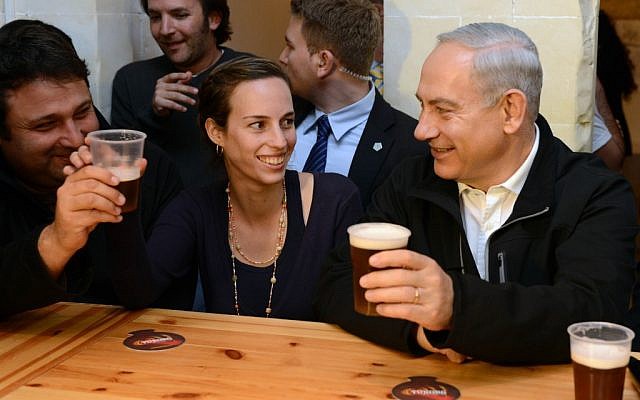 Feeling good about the elections, Prime Minister Benjamin Netanyahu has a drink with students in Beersheba (photo credit: Kobi Gideon/GPO/Flash90)
