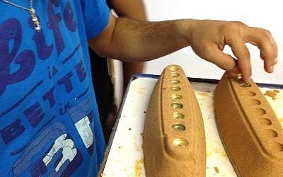 A young team member works on some of the sand menorahs (Photo credit: Courtesy)