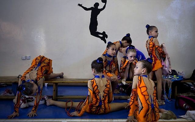 Gymnasts from Russian-speaking immigrant families warm up at a gymnastics competition organized for Israel's immigrant community, in the southern resort city of Eilat. Most of Israel's Olympic gymnasts are immigrants from the former Soviet Union. (photo credit: AP Photo/Oded Balilty) 