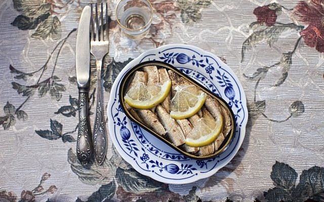 Canned sardines are served at a family dinner at the home of Moldovan immigrant Puma Rotner in Ashdod. Rotner left her native city of Bendery in Moldova in 2006, bringing her dishes and silverware to Israel. (photo credit: AP Photo/Oded Balilty) 