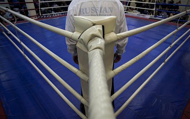 A Russian-speaking Israeli immigrant referee stands in the ring during a boxing competition for Israeli youth, in the southern Israeli town of Kiryat Gat. Many of Israel's boxing clubs are run by immigrants from the former Soviet Union (photo credit: AP Photo/Oded Balilty)