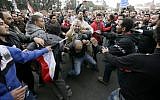 In this Wednesday, Dec. 5, 2012 file photo, Egyptian President Mohammed Morsi’s supporters beat an opponent, center, during clashes outside the presidential palace, in Cairo, Egypt (photo credit: AP/Hassan Ammar)