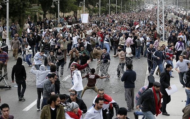 Supporters and opponents of Egyptian president Mohammed Morsi clash outside  the presidential palace in Cairo earlier this month (photo credit: AP/Hassan Ammar)