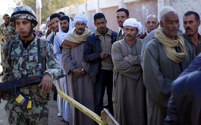 Egyptians line up outside a polling station wait their turn to cast their votes on Saturday, Dec. 22, 2012, during the second round of a referendum on a disputed constitution drafted by Islamist supporters of President Mohammed Morsi. in Fayoum, about 100 kilometers south of Cairo.(photo credit: Khalil Hamra/AP)