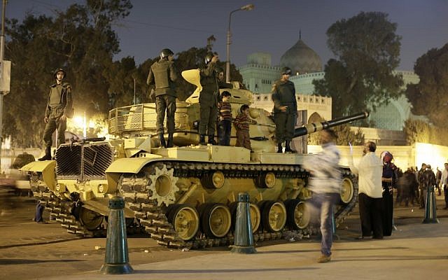An Egyptian protester takes a picture with his mobile of his children on top of an Egyptian army tank outside the presidential palace in Cairo, Egypt, Saturday, Dec. 8, 2012 (photo credit: AP/Hassan Ammar)
