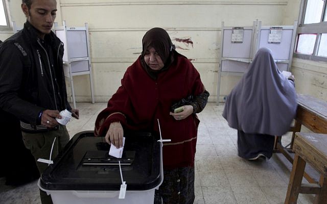 An Egyptian woman casts her vote during a referendum on a disputed constitution drafted by Islamist supporters of President Morsi in Cairo, Egypt, Saturday, Dec. 15, 2012. (photo credit: AP Photo/Khalil Hamra)