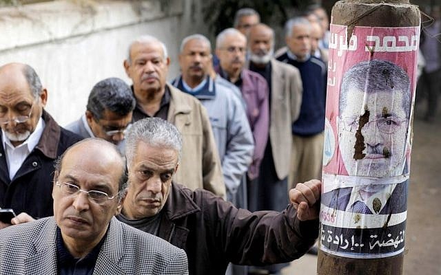 Egyptians wait in line outside a polling station to cast their votes in a referendum on a disputed constitution drafted by Islamist supporters of President Mohammed Morsi in Cairo, Saturday. (AP Photo/Amr Nabil)