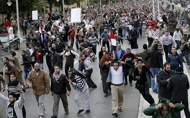 Egyptian President Mohammed Morsi’s supporters clash with opponents, not pictured, outside the presidential palace, in Cairo, Egypt, on December 5. (photo credit: AP/Hassan Ammar) Egyptian President Mohammed Morsi’s supporters clash with opponents, not pictured, outside the presidential palace, in Cairo, Egypt, on December 5. (photo credit: AP/Hassan Ammar)