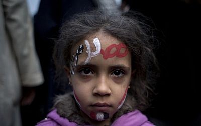 A girl with the colors of Egypt's national flag and Arabic text that reads 'Egypt, Morsi,' painted, at a demonstration in front of Egypt’s top court in Cairo, Sunday, December 2, 2012 (photo credit: AP/Nasser Nasser)