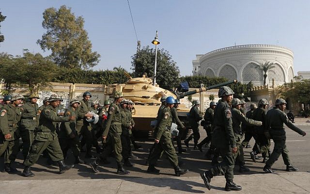 Egyptian soldiers walking past a military tank that secures the presidential palace in Cairo on December 13, 2012. (photo credit: Petr David Josek/AP) Egyptian soldiers walking past a military tank that secures the presidential palace in Cairo on December 13, 2012. (photo credit: Petr David Josek/AP)