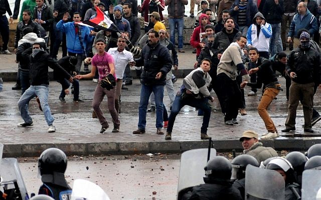 Opponents of Egyptian President Mohammed Morsi clash with Islamist supporters of the president, unseen, as a cordon of riot police separates the groups in Alexandria, Egypt, Friday, Dec. 21 (photo credit: AP) Opponents of Egyptian President Mohammed Morsi clash with Islamist supporters of the president, unseen, as a cordon of riot police separates the groups in Alexandria, Egypt, Friday, Dec. 21 (photo credit: AP)