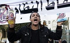 An Egyptian protester  chants anti-Muslim Brotherhood and Egyptian President Mohammed Morsi slogans outside the presidential palace under a banner with a defaced picture of president Mohammed Morsi and Arabic that reads 'the people want to bring down the regime,' in Cairo, Egypt, Saturday. (AP Photo/Hassan Ammar)