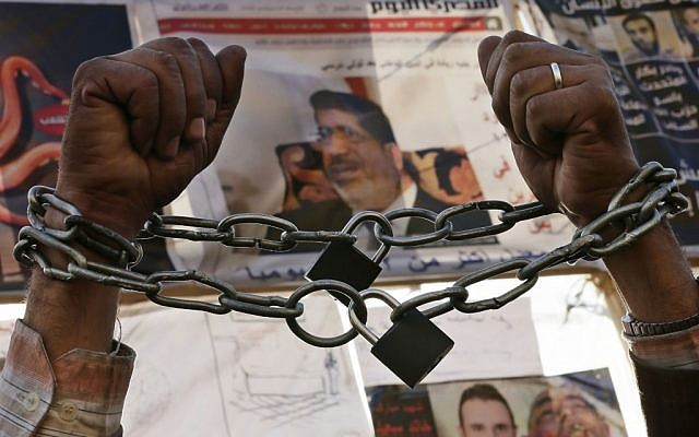 A protester chains his hands during a protest in Tahrir Square in Cairo, Egypt, Monday, Dec. 17, 2012. (photo credit: Hassan Ammar/AP)