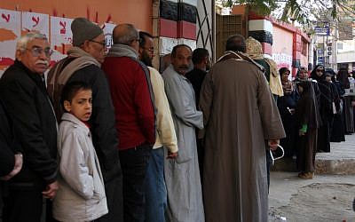 Egyptians line up outside a polling station as they wait their turn to cast their votes in the second round of a referendum on a disputed constitution drafted by Islamist supporters of President Mohammed Morsi in Fayoum, about 100 kilometers (62 miles) south of Cairo on Saturday, December 22. (photo credit: AP/Khalil Hamra)