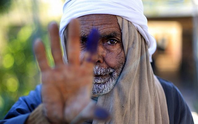 An Egyptian elderly man shows his inked finger after casting his vote in the second round of a referendum on a disputed constitution drafted by Islamist supporters of President Mohammed Morsi in Fayoum, Egypt, on Saturday. (photo credit: AP/Khalil Hamra)
