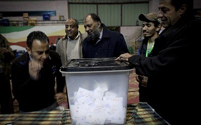Egyptian election workers at a polling station in Giza, Egypt unseal a ballot box for counting at the end of the second round of the referendum for the Islamist-backed constitution on December 22, 2012. (photo credit: Nasser Nasser/AP)