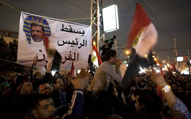 Egyptian protesters carry national flags and chant anti-Muslim Brotherhood slogans during a demonstration in front of the presidential palace in Cairo, Egypt, on Tuesday, December 4, 2012 (photo credit: AP Photo/Nasser Nasser)