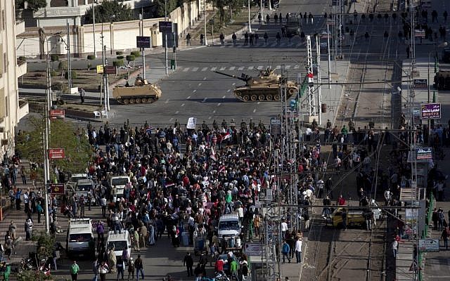 Egyptian army tanks secure the perimeter of the presidential palace while protesters gather chanting anti president Mohammed Morsi slogans, in Cairo, Egypt, on Friday, December 7. (photo credit: AP/Nasser Nasser)
