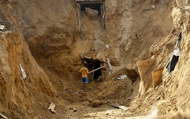 A Palestinian man works at the entrance of a destroyed smuggling tunnel along the Egypt Gaza border in Rafah, southern Gaza Strip, on November 27, 2012. (photo credit: AP Photo/Adel Hana, File)