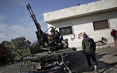 A Syrian rebel checks an anti-aircraft weapon, in Maaret Misreen, near Idlib, Syria, on Monday, Dec. 14 (photo credit: AP/Muhammed Muheisen)